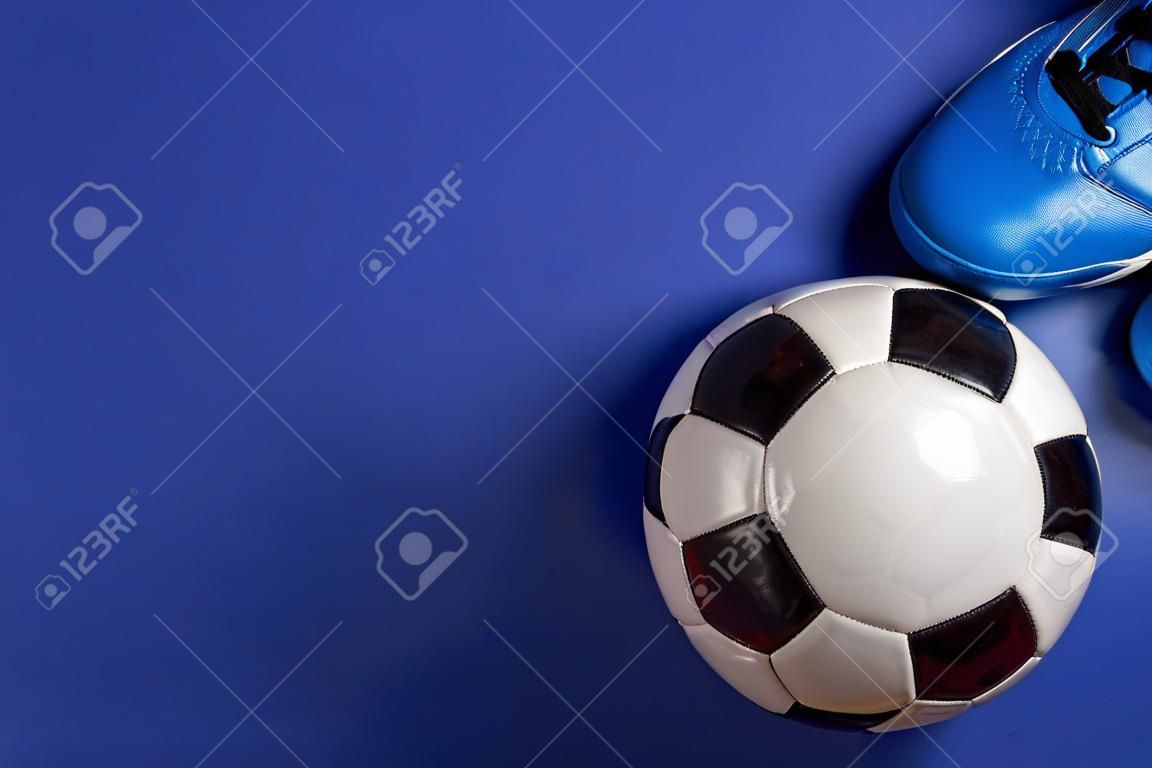 Soccer ball under soccer players feet on blue background