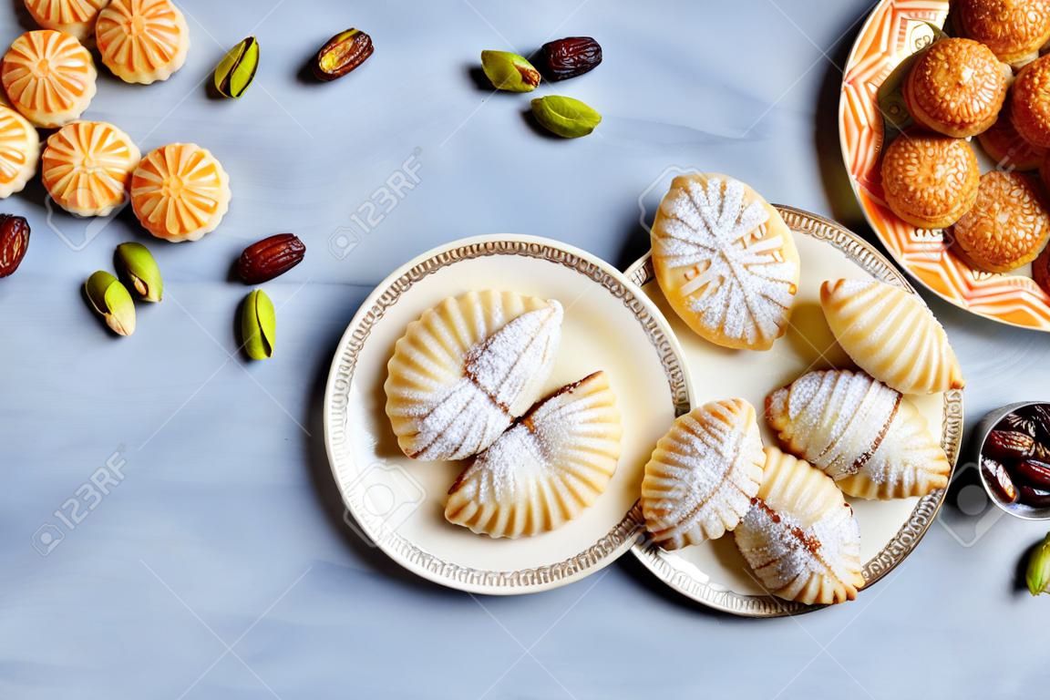 Arabic sweets. Traditional eid semolina maamoul or mamoul cookies with dates, walnuts and pistachio nuts. Top view, copy space