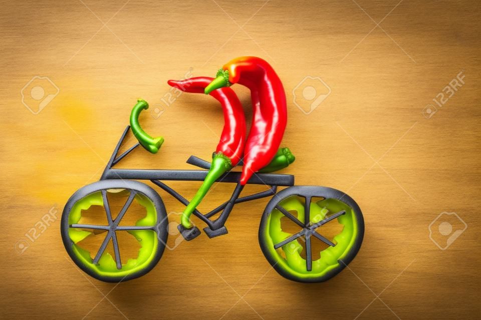 Healthy eating  Two little funny peppers on bicycle 
