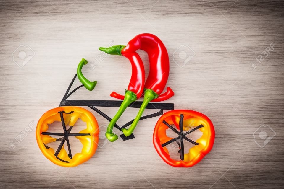 Healthy eating  Two little funny peppers on bicycle 