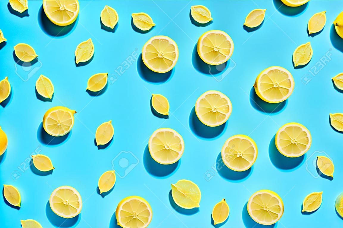 Padrão de limão no fundo azul claro brilhante. Textura de comida plana mínima. Conceito fresco abstrato da moda do verão.