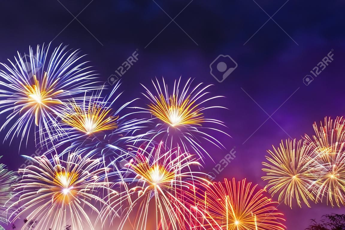 Fuochi d'artificio dai colori vivaci su sfondo crepuscolare. Sfondo astratto di fuochi d'artificio colorati con spazio libero per il testo.