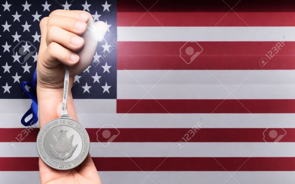 Sosteniendo medalla de plata para el deporte y la bandera nacional de nosotros