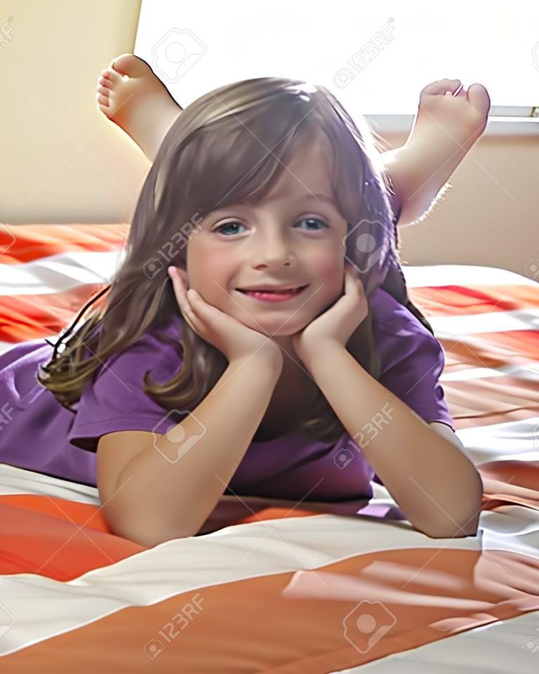 little girl lying on a bed