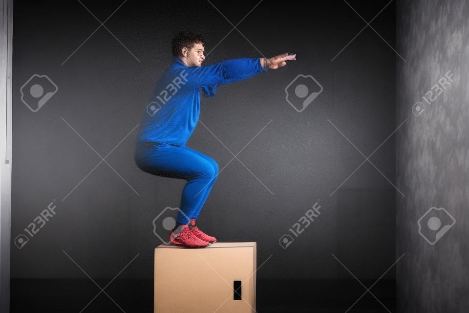 Foto di uno sportivo che allena il suo corpo in box jumping.