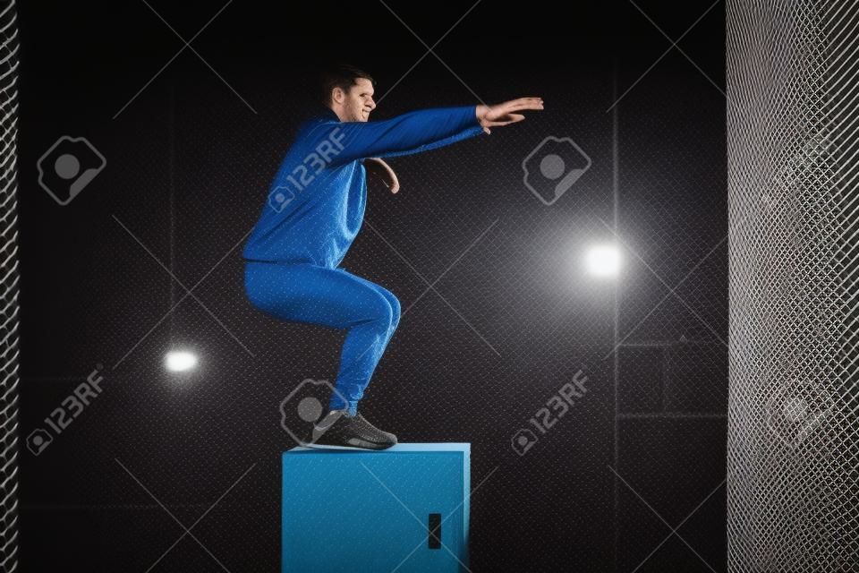 Foto di uno sportivo che allena il suo corpo in box jumping.