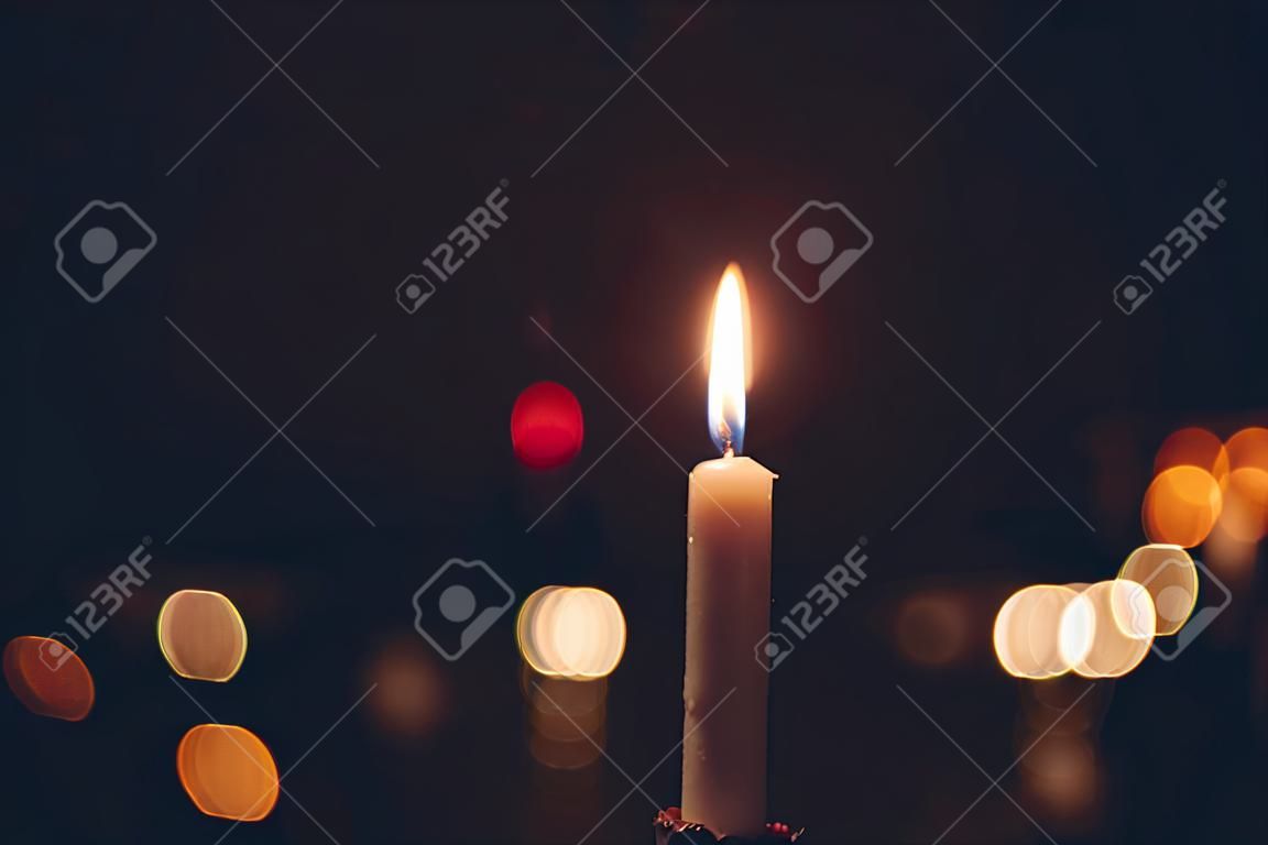 Candles Burning at Night. White Candles Burning in the Dark with focus on single candle in foreground