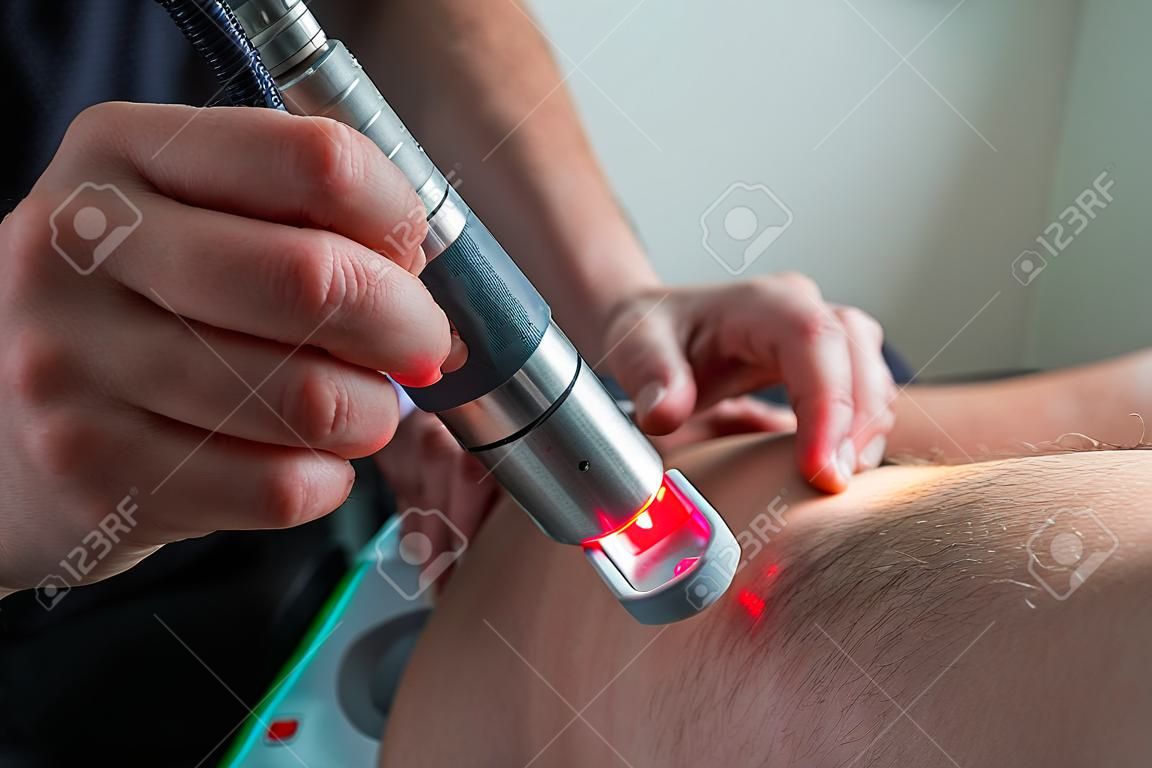 Laser therapy on a knee used to treat pain. selective focus