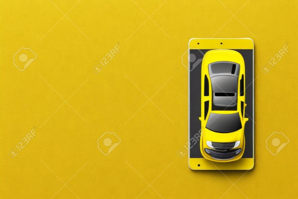 Carro de brinquedo de táxi amarelo e smartphone no fundo amarelo com espaço de cópia.
