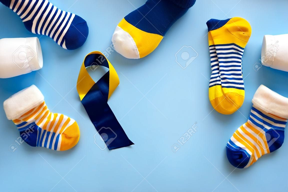 World Down syndrome day background. Down syndrome awareness concept. Socks and ribbon on blue background