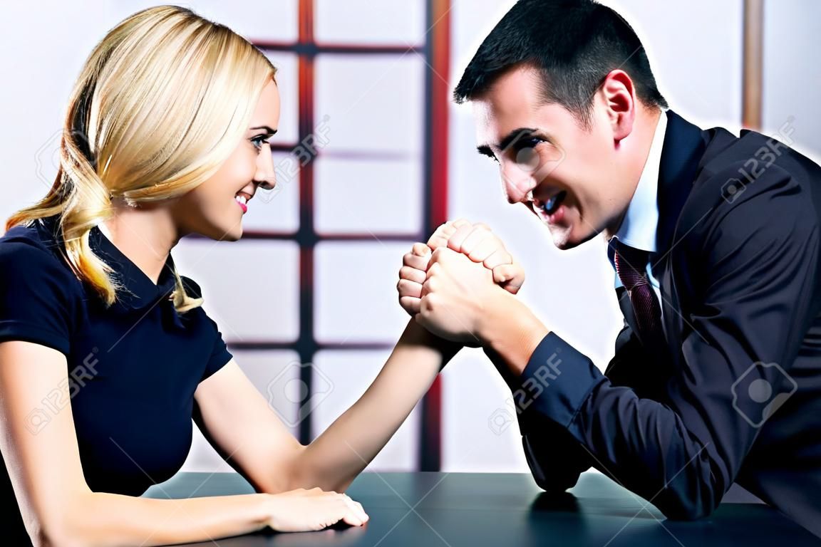 Junges Paar glücklich oder Geschäftsleute, die Kämpfe im Arm-Wrestling