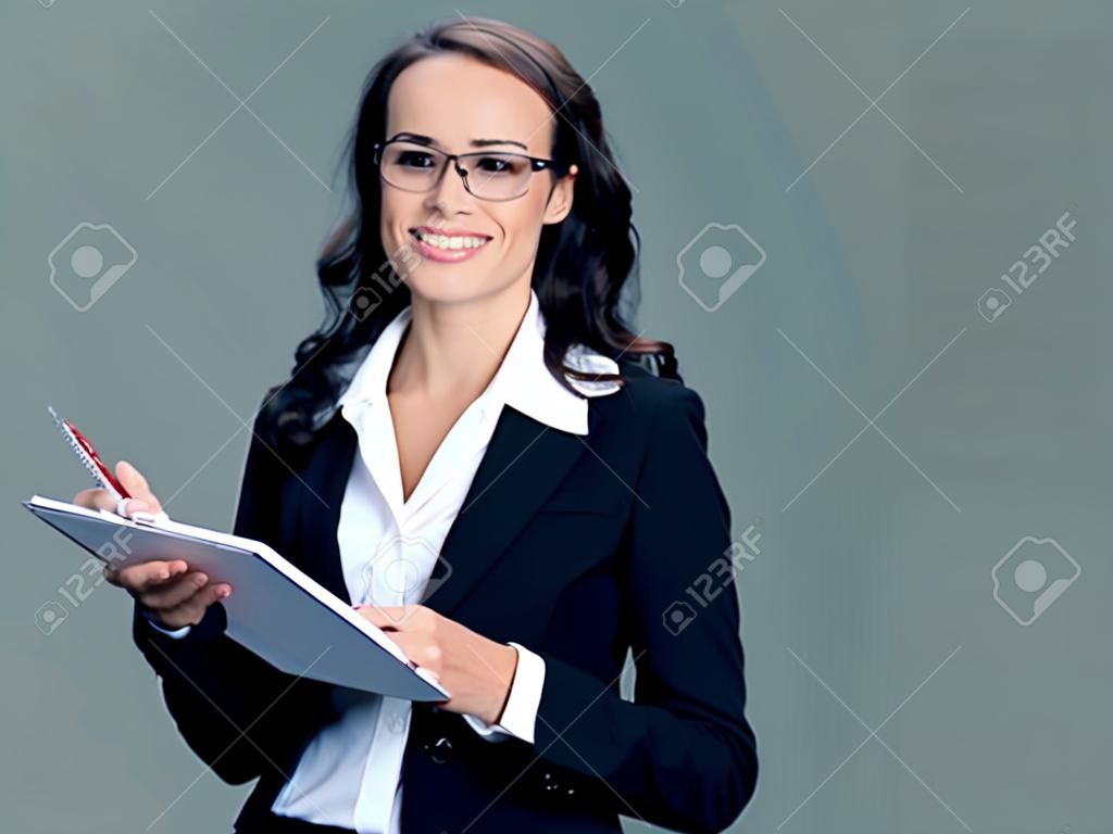 Cheerful smiling businesswoman in black suit with notepad or organizer, with blank copyspace area for slogan or text