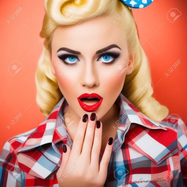 Portrait of beautiful young surprised woman, dressed in pin-up style. Caucasian blond model posing in retro fashion and vintage concept studio shoot.