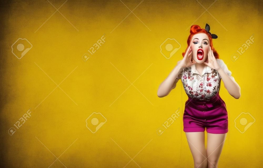 우와! 입을 벌린 채 손을 잡고 무언가를 말하거나 외치는 여성의 초상화. 핀업걸. 노란색의 복고풍 빈티지 스튜디오 컨셉의 빨간색 보라색 머리 모델입니다. 복사 공간을 조롱합니다.