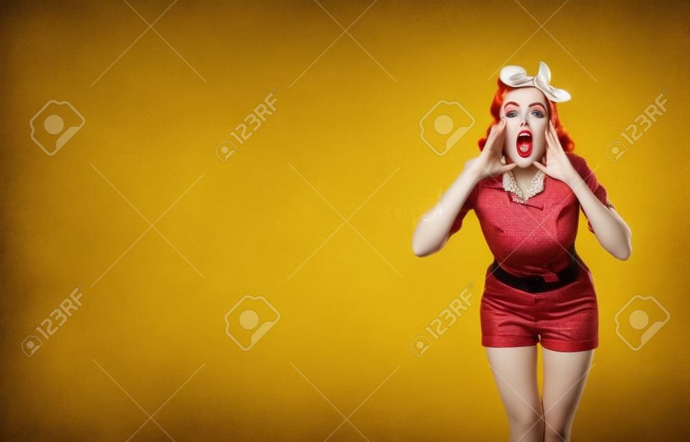 WOW! Portrait of woman holding her hands near open mouth and saying or shouting something. Pin up girl. Red purple haired model in retro vintage studio concept, on yellow color. Copy space mock up.