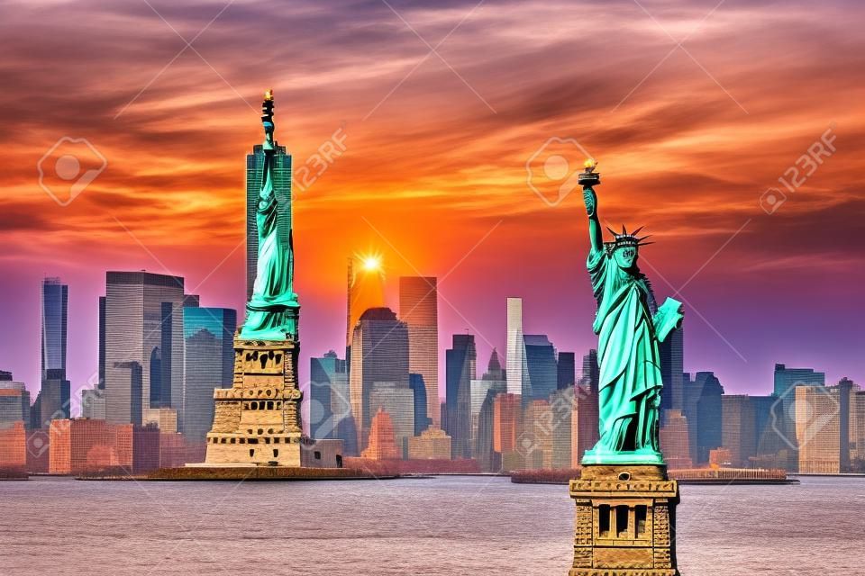 Freiheitsstatue mit Hintergrund der Skyline von New York City Manhattan bei Sonnenuntergang von New Jersey.