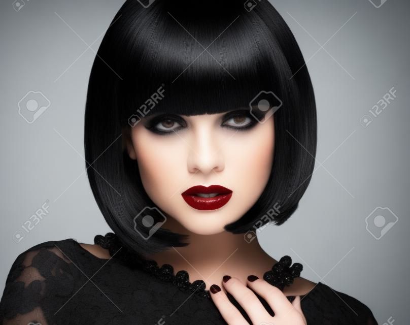 Fashion Brunette-Mädchen-Modell mit schwarzem Bob Frisur. Lady Vamp. Frau mit kurzen Haaren isoliert auf weißem Hintergrund Studio.