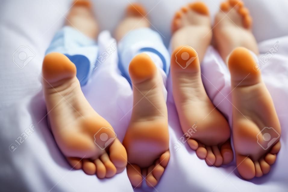 niños acostados en la cama, primer plano de los pies de los niños