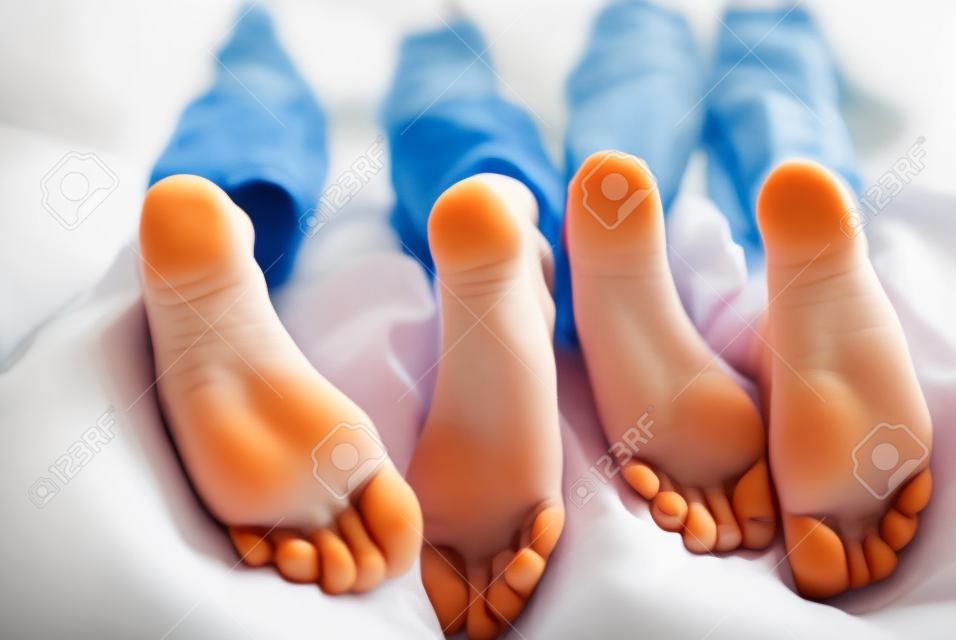 niños acostados en la cama, primer plano de los pies de los niños