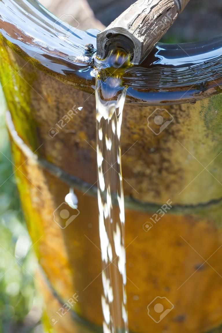 Un jet d'eau provenant d'un trou dans un vieux tuyau rouillé