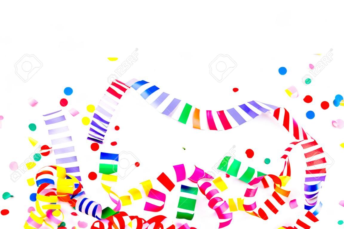 Coriandoli di carta colorati e serpentine colorate a spirale su uno sfondo bianco con copyspace in un biglietto di auguri e un modello di invito a una festa per il matrimonio o il compleanno di Natale di Capodanno