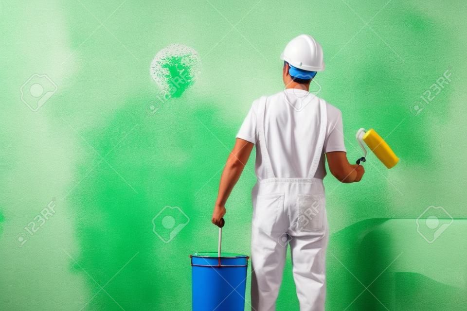 painter man at work with a paint roller and bucket, wall painting concept
