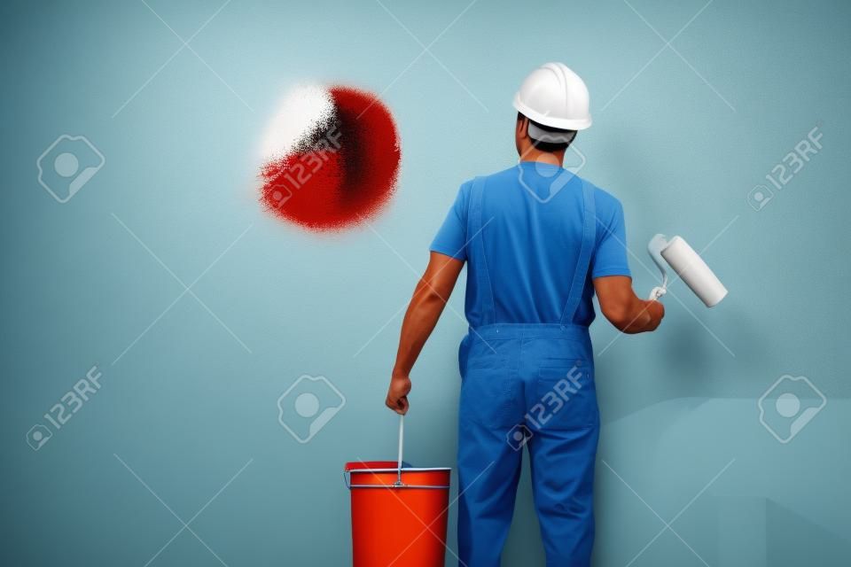 painter man at work with a paint roller and bucket, wall painting concept