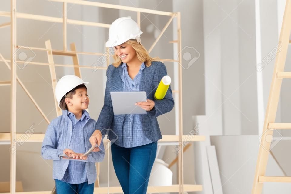 vrouw interieur ontwerper of architect moeder met haar zoon aan het werk, ze kiezen kleuren van kleur swatch om het huis te versieren, binnen de bouwplaats.
