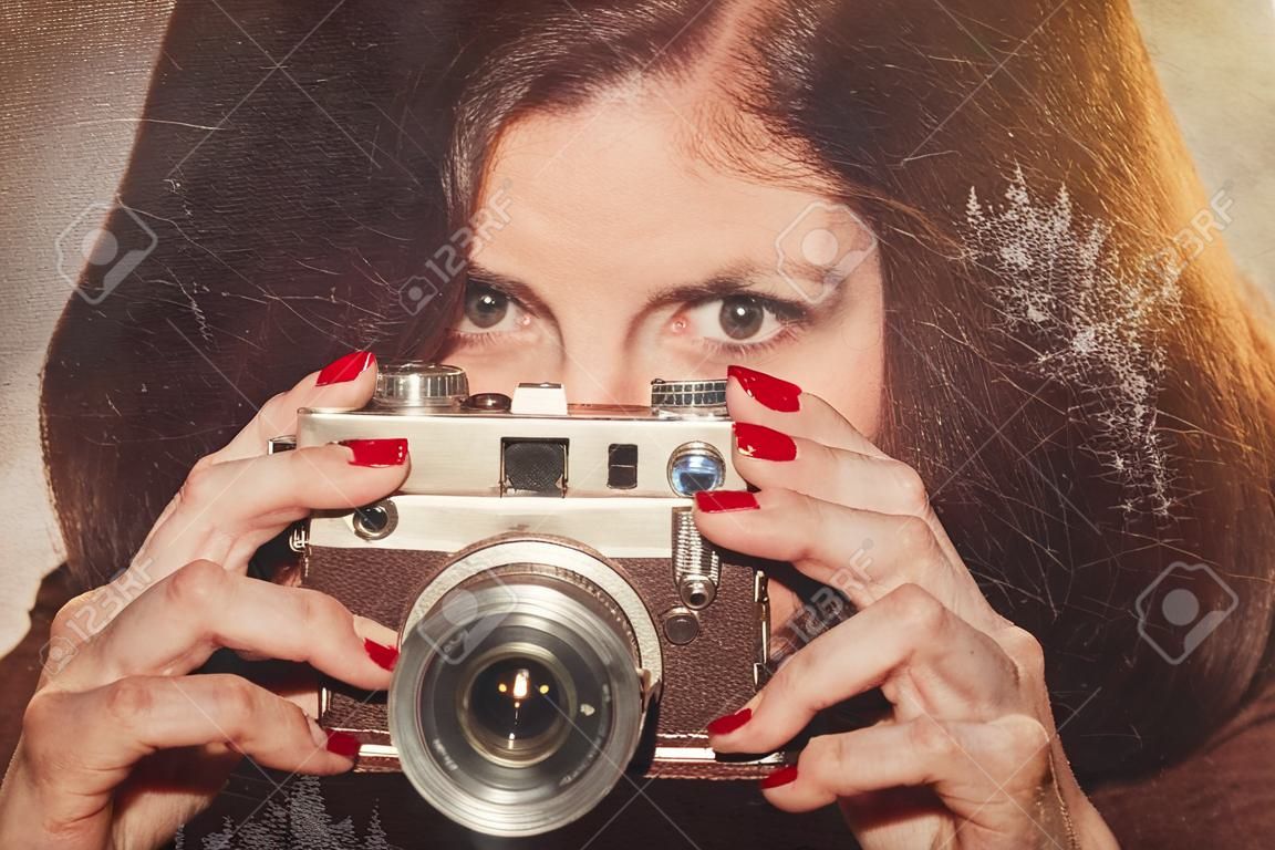 Portrait of young woman with retro camera. Stylized as old paper photo
