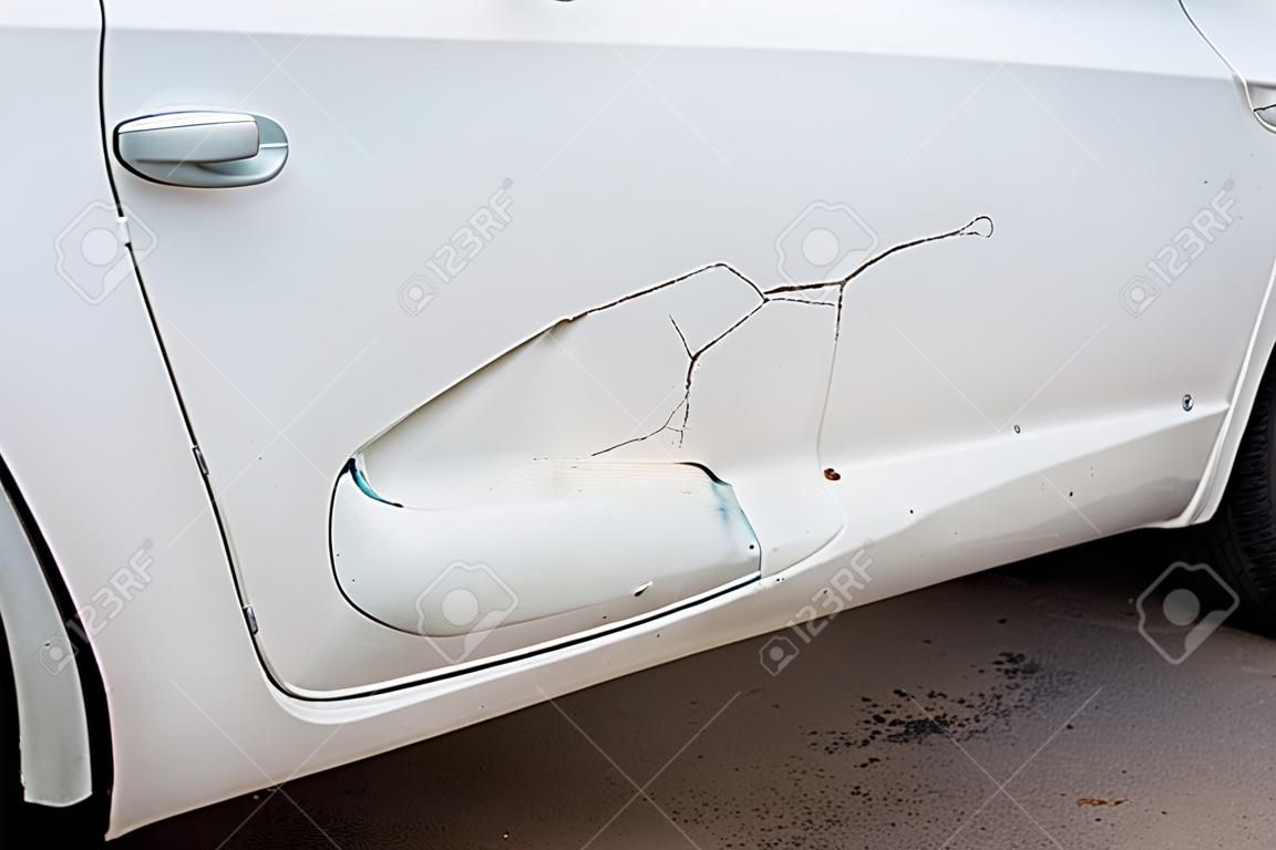 Dent, scratch on the white car door paint