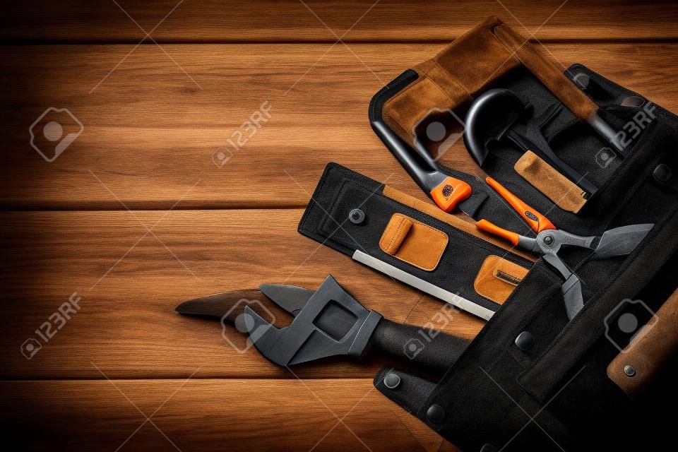 Professional tools for the master builder in a suede bag on a black vintage table. Free space for advertising. Tool preparation before construction.