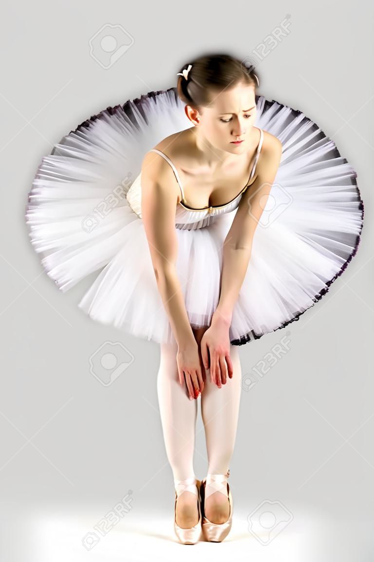 klassische Ballerina in einem weißen Rock auf schwarzem Hintergrund