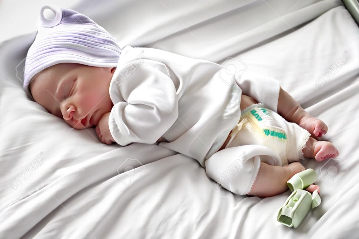 Newborn boy bambino che dorme sul letto d'ospedale