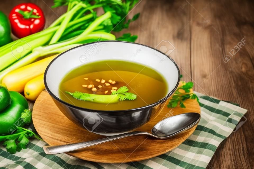 木製のテーブルに新鮮な野菜とスープのボウル