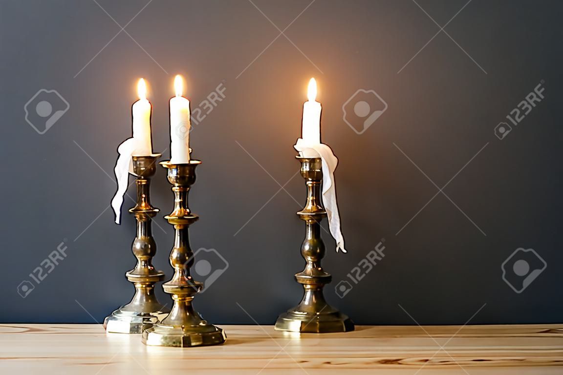 Retro Kandelaber mit brennenden Kerzen im minimalistischen Zimmer