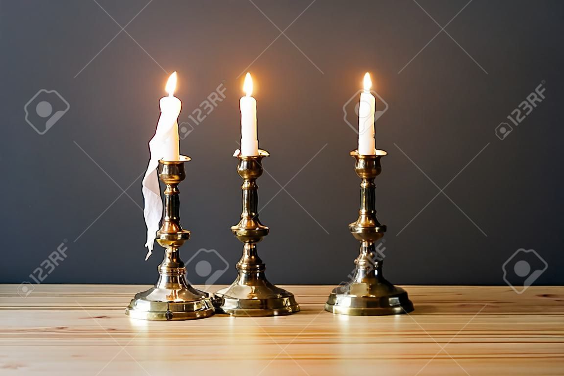 Retro Kandelaber mit brennenden Kerzen im minimalistischen Zimmer