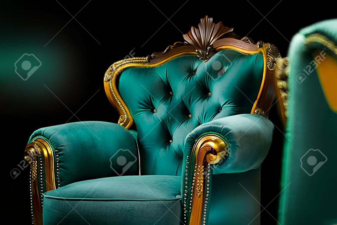 Interior de estilo antiguo, lujoso sillón verde y dorado vintage