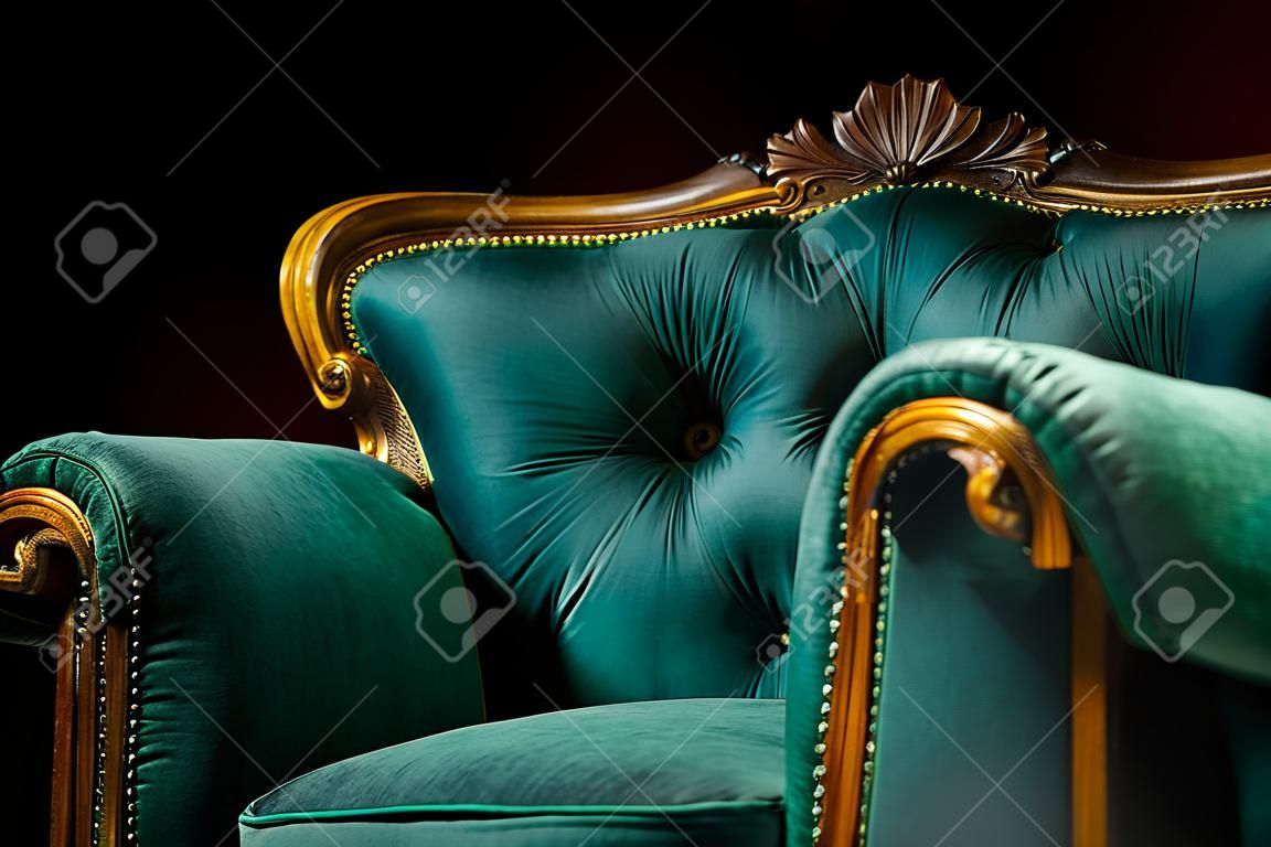 Interior de estilo antiguo, lujoso sillón verde y dorado vintage