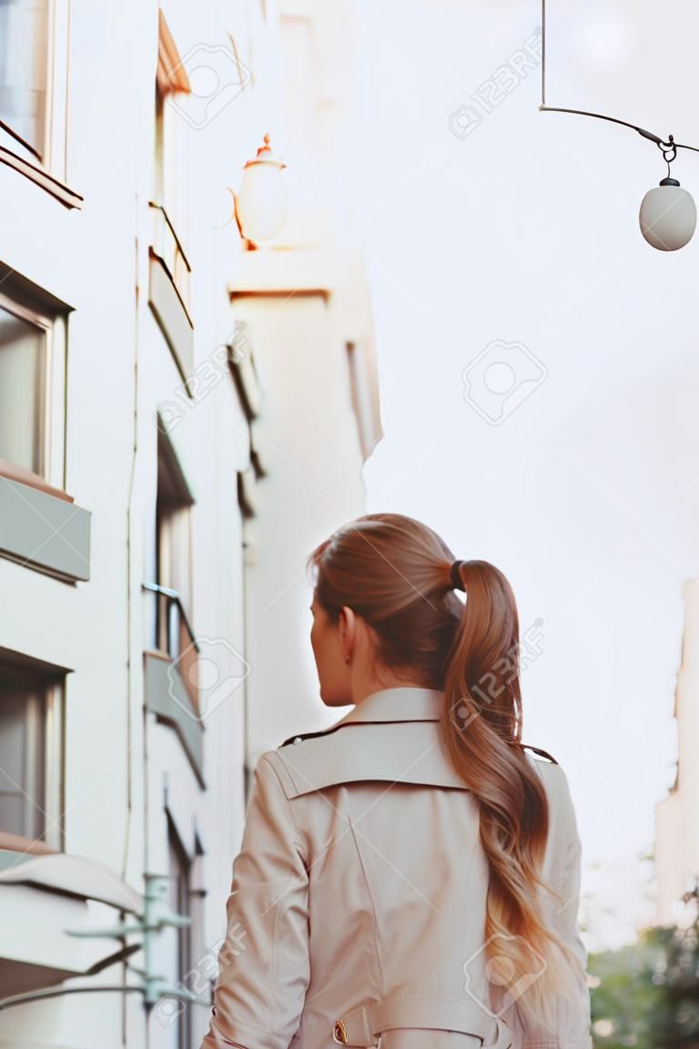 Donna con bei capelli in piedi e guardando al panorama di new york city. vista posteriore.