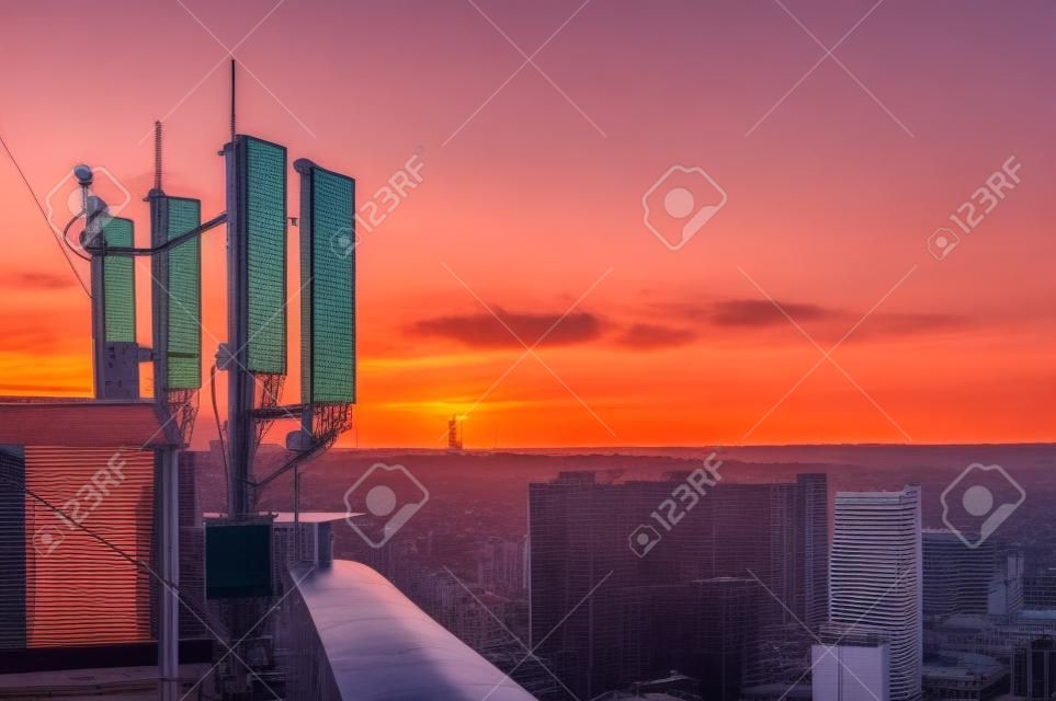 cellular communications tower on a background of the city and beautiful sunset in summer