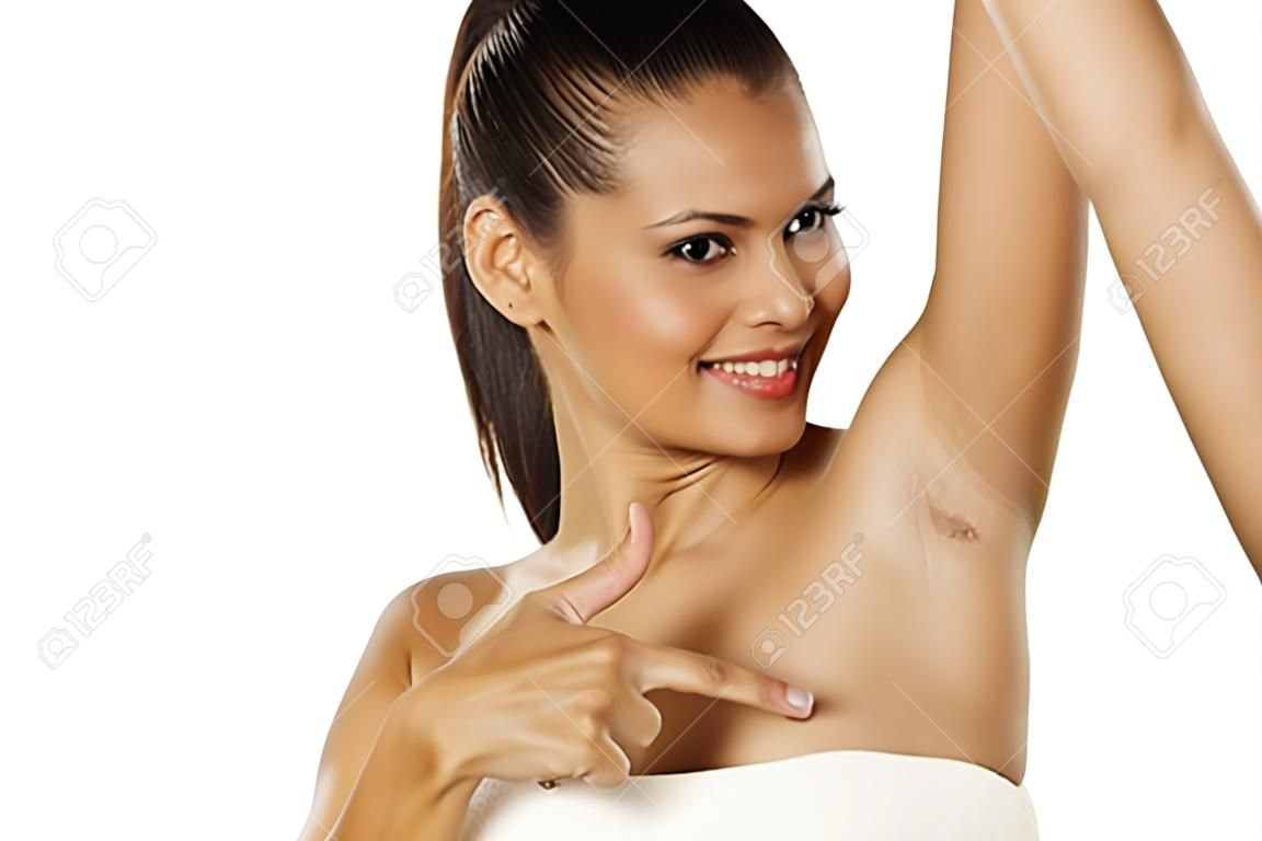Улыбается молодая этническая женщина показывает ее бритая подмышка и показывает палец вверх
