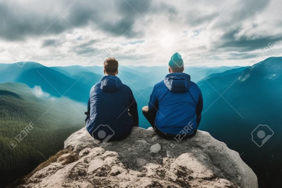 Dwóch mężczyzn cieszących się widokiem ze szczytu góry odpowiednim do tematów podróży i przygód