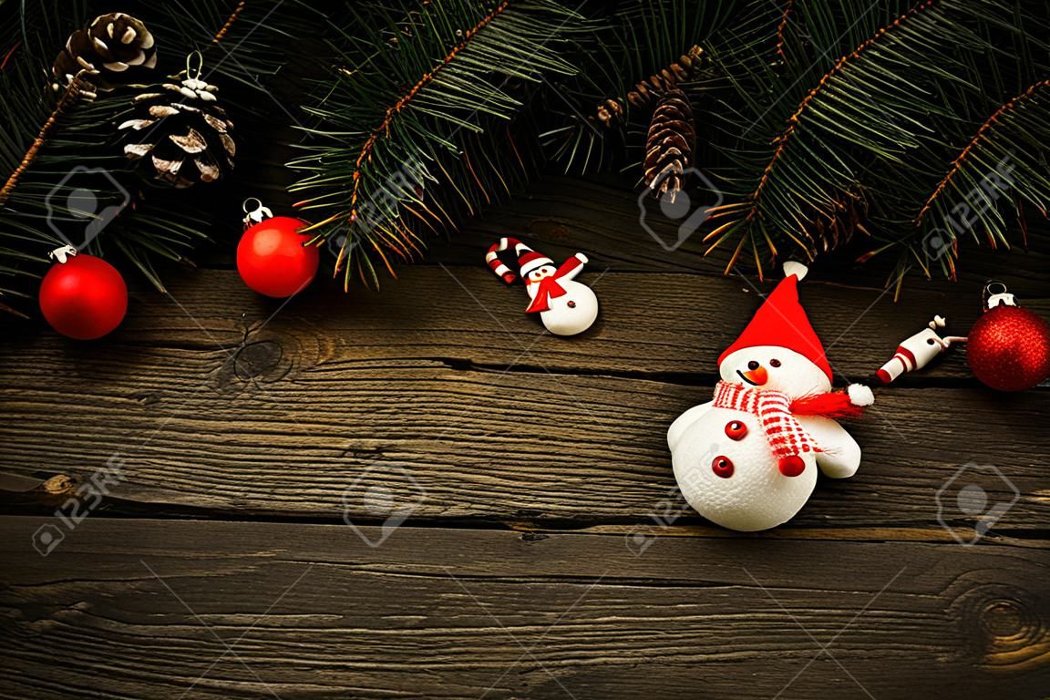 branches d'arbres de Noël avec des décorations de Noël et bonhomme de neige sur la texture en bois.