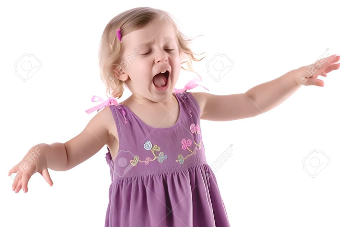fretful little girl wearing a purple dress screaming with one's tongue hanging out and standing on white background