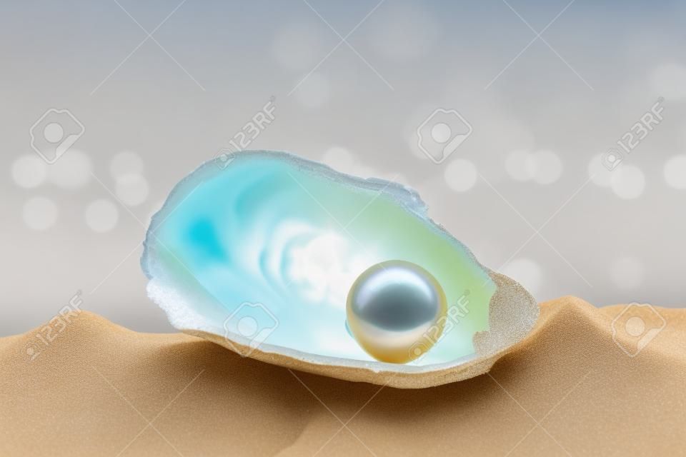 Shell con una perla su una sabbia di mare.