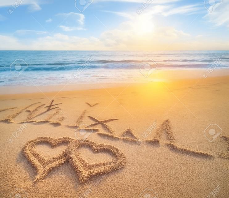 Corações desenhados na areia da praia.