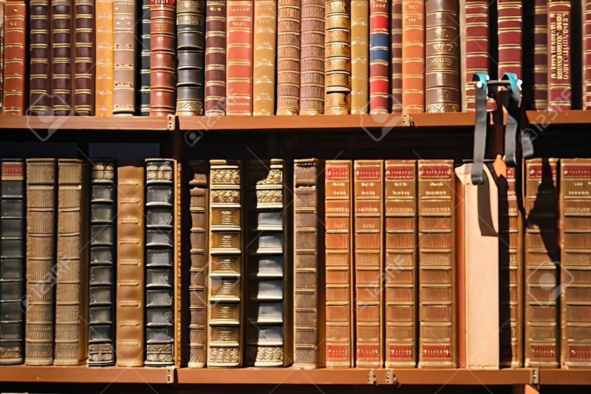 Старые книги, стоящие на полке библиотеки