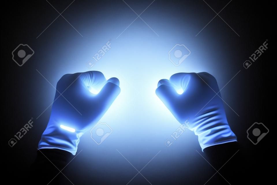 A white gloved hand isolated on black background. Clenched fists.
