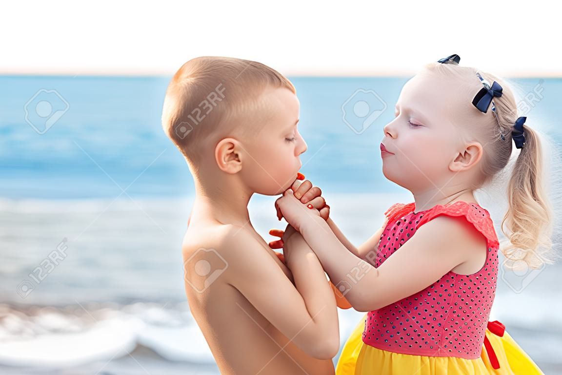 ritratto di due bambini che si baciano sulla spiaggia