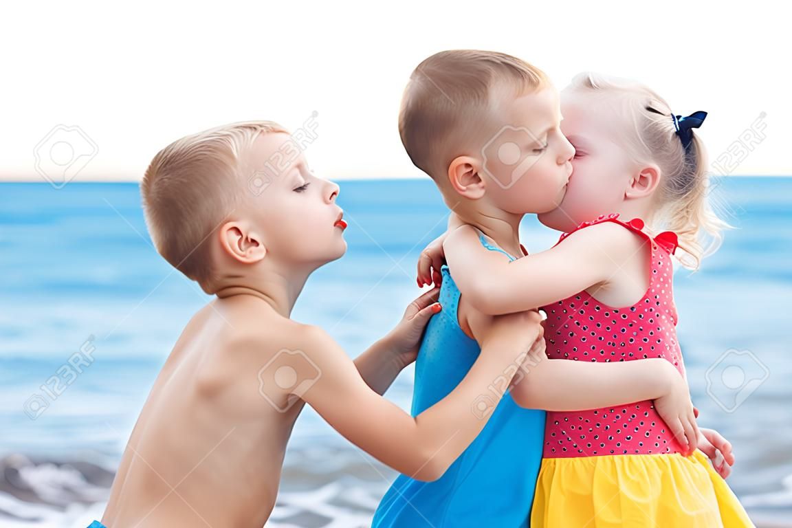 Retrato de dos niños que se besan en la playa